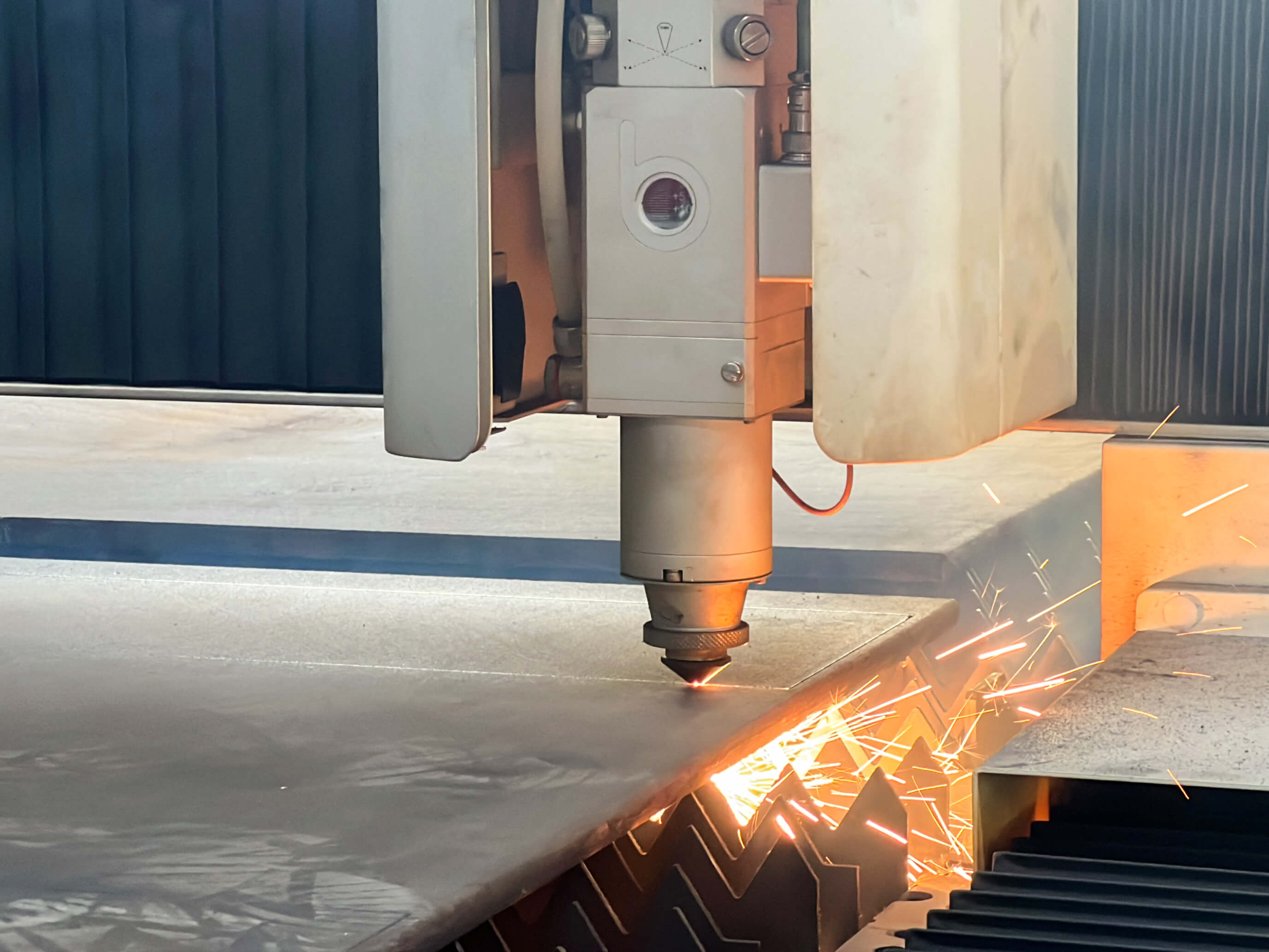 A laser cutting machine creating sparks while cutting metal.